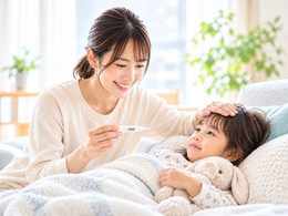 体調不良の子どもを優しく看病する日本人の母親